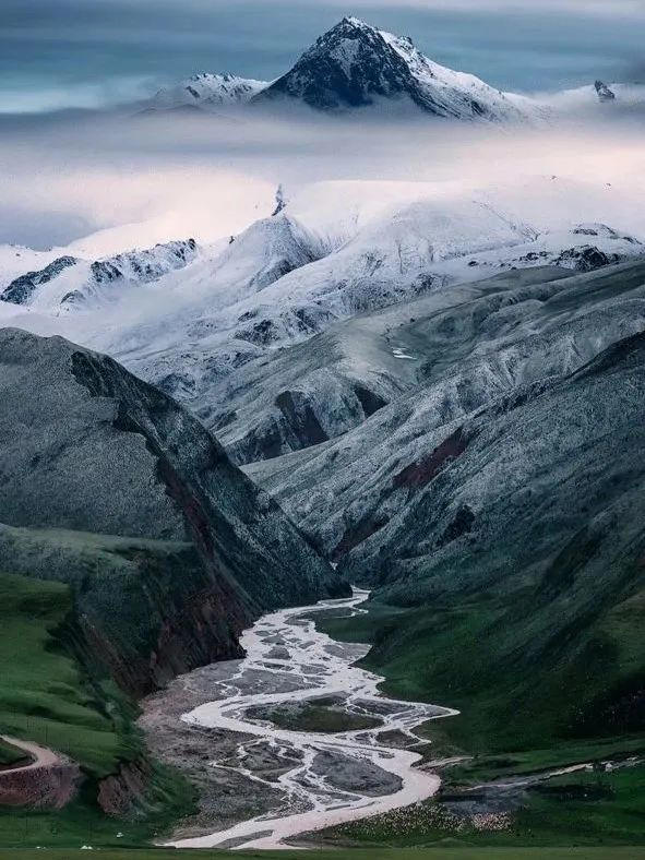 我的故乡，最不缺的就是山。  从一个镇子到另一个镇子要翻越好几座大山，公路绕山而行，从一片薄雾驶向另一片薄雾，弯弯绕绕十几折，潮意的空气吸进肺里，带着某种绵长又刺骨的烦闷。  此时，山不再是山，不是偶然地质事件形成的岩石、飞泉和冰雪