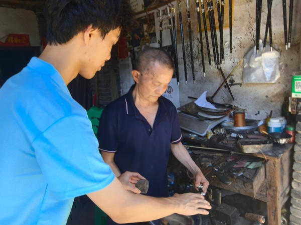 服务队成员采访手工木秤制作者王泽喜老人。重庆财经学院供图