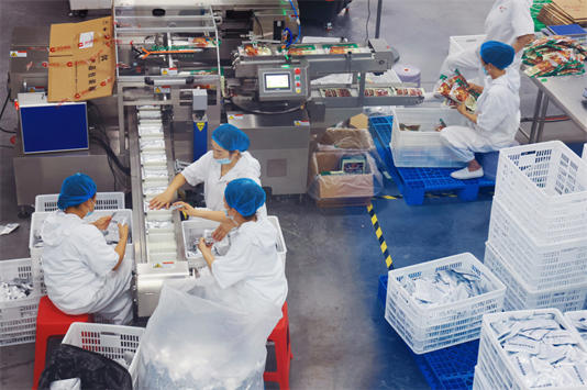 工人正对火锅食材进行包装。张舰木供图