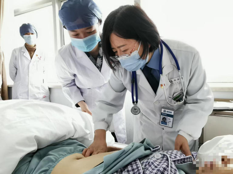 中华医学会肝病学分会副主任委员、空军军医大学西京医院消化内科主任医师韩英为患者查体。新华社发