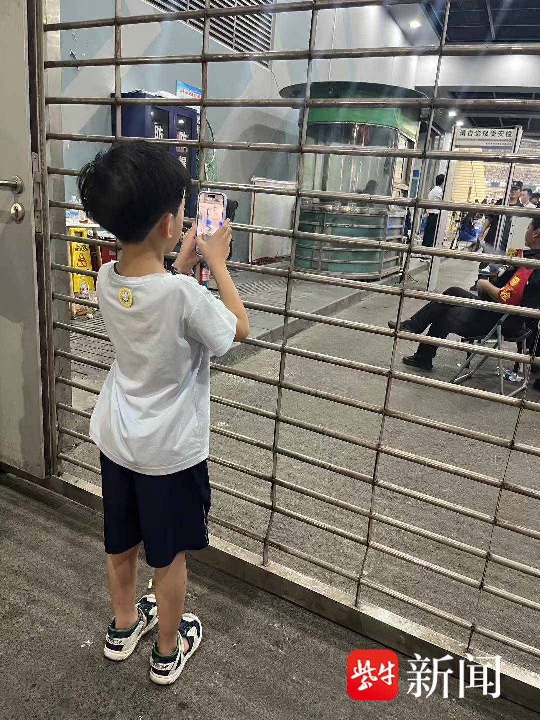 “苏超”场外通道挤满球迷 6岁男孩举妈妈手机拍照：希望下一场能抢到票