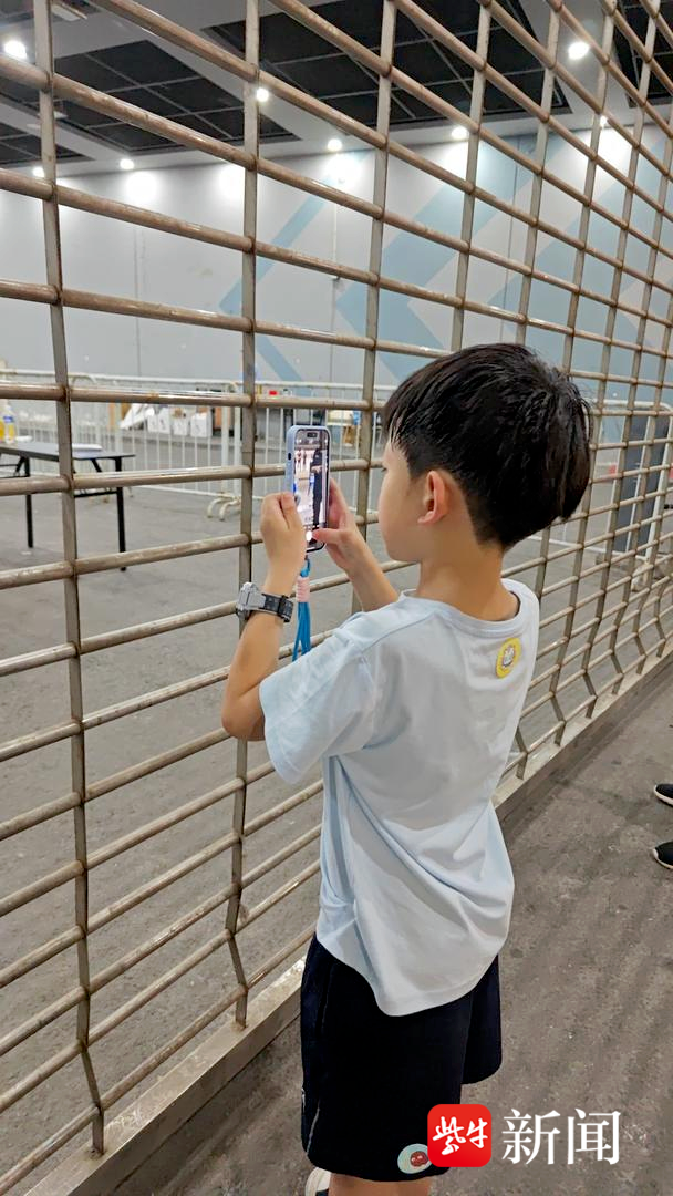 “苏超”场外通道挤满球迷 6岁男孩举妈妈手机拍照：希望下一场能抢到票