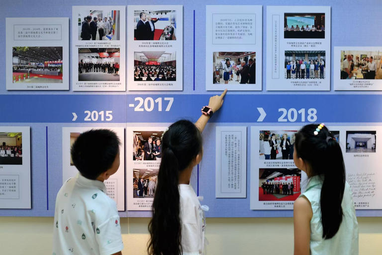 2025年8月9日，在山东省青岛市勘察测绘研究院地图文化展厅，嘉定路小学的学生在参观历届地图文化节图片展览。