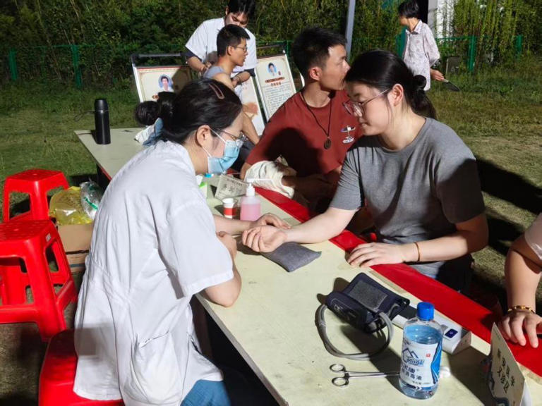 中医夜市，中医医师为游客问诊把脉。