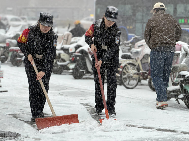 12日，石家庄市公安局轨道交通分局警员及时清理进站口的积雪。新华社发