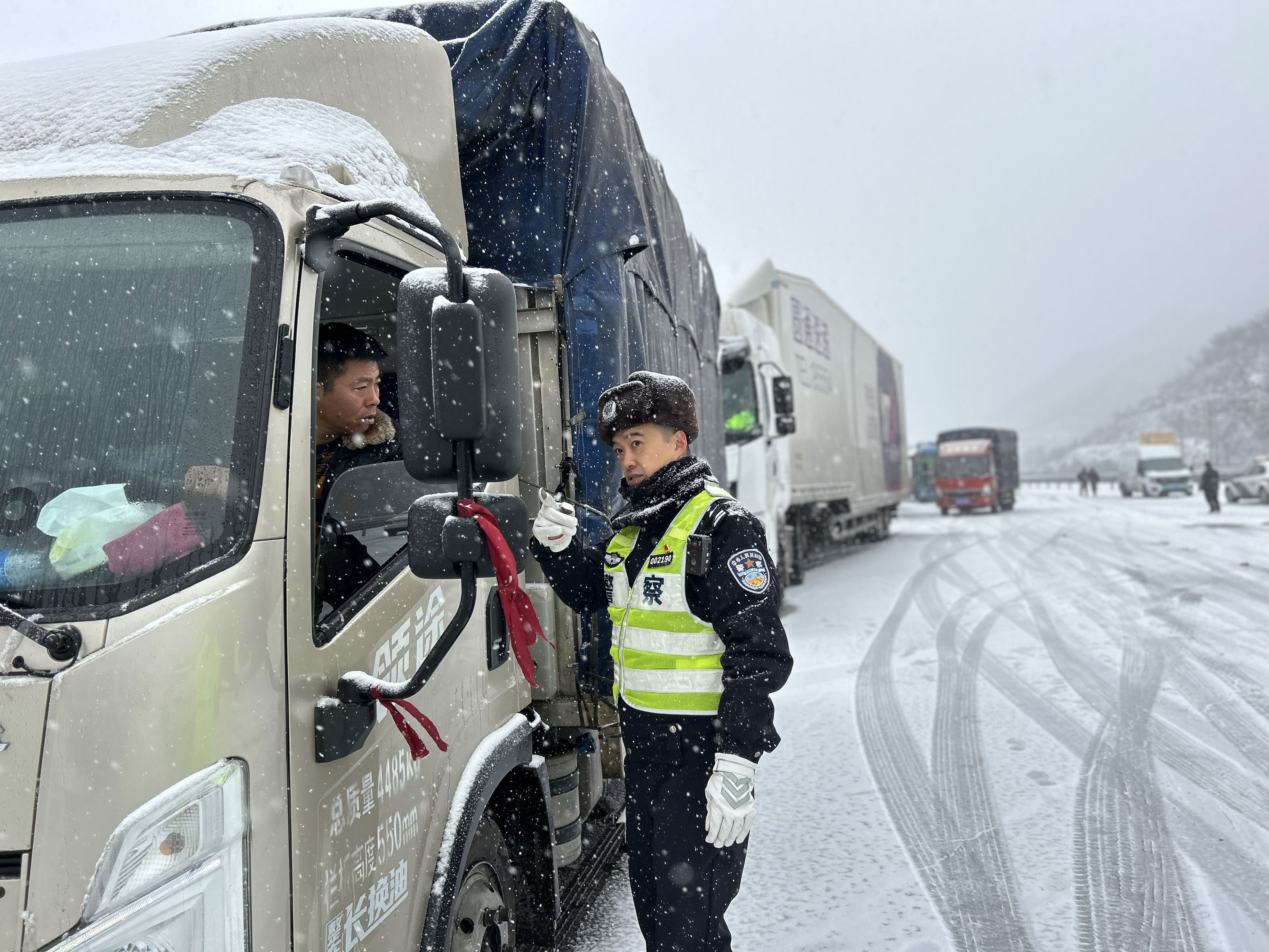 12日，河北高速交警在雪中坚守岗位，引导大车司机安全行驶。新华社发