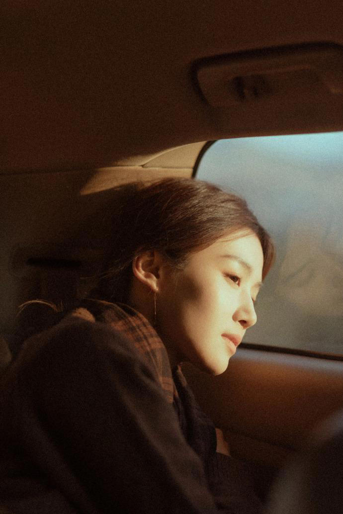 卢昱晓身穿褐色大衣 微倚车窗气质清冷